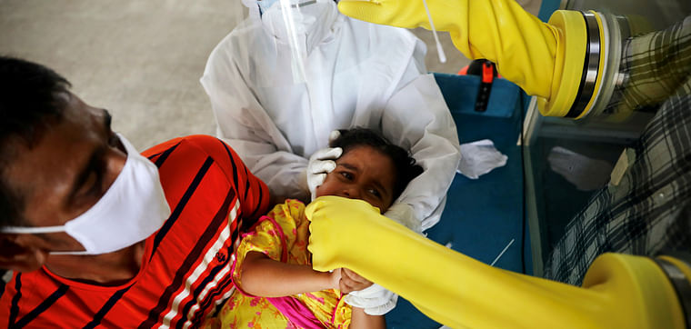 A health worker collects a swab sample from a child at Mugda Medical College and Hospital, as the coronavirus disease (COVID-19) outbreak continues, in Dhaka, Bangladesh, on 23 June 2020