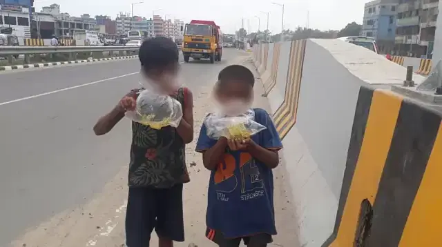 Two small children inhaling 'dandi' on the Dhaka -Mawa highway