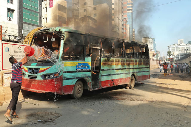 A  man tries to blaze the bus fire in Dhaka on 12 November 2020