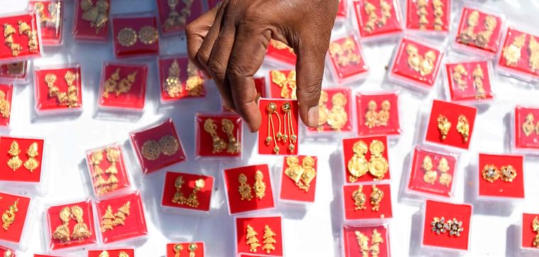 A vendor displays gold plated earrings as he waits for customers at a Friday market in Chennai on 27 November 2020