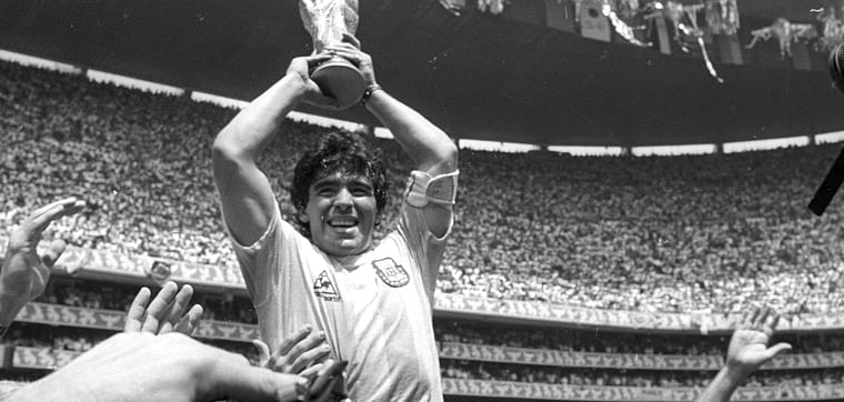 Argentine star Diego Maradona holds up the World Cup trophy as he is carried off the field after Argentina defeated West Germany 3-2 to win the World Cup soccer championship in Mexico City 29 June, 1986.