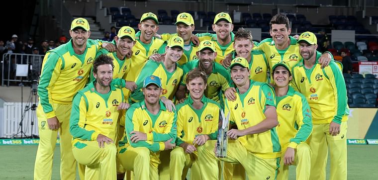 Australian team pose for pictures with the winning trophy of the one-day international cricket series against India at Manuka Oval in Canberra on 2 December 2020