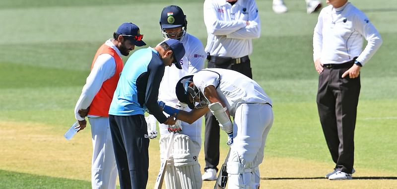 India's Mohammed Shami (C) receives treatment on his arm before retiring hurt on the third day of the first cricket Test match between Australia and India in Adelaide on 19 December, 2020