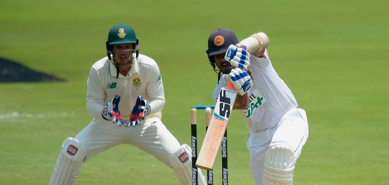 Sri Lanka's Dinesh Chandimal (R) watches the ball after playing a shot as South Africa's captain and wicketkeeper Quinton de Kock (L) looks on during the first day of the first Test cricket match between South Africa and Sri Lanka at SuperSport Park in Centurion on 26 December, 2020.
