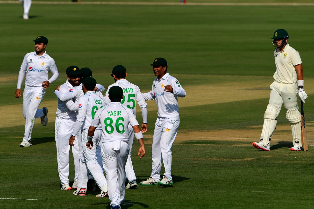 Pakistan's players (L) celebrate the wicket of South Africa's Aiden Markram during the first day of the first cricket Test match between Pakistan and South Africa at the National Stadium in Karachi on 26 January , 2021