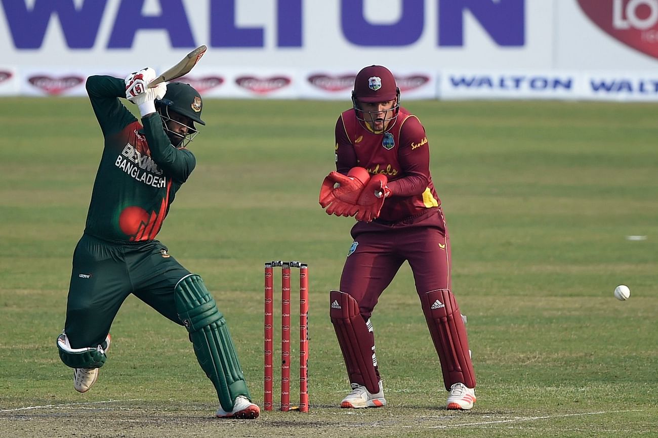 Bangladesh's captain Tamim Iqbal (L) plays a shot as West Indies' wicketkeeper Joshua Da Silva watches during the second one-day international (ODI) cricket match between Bangladesh and West Indies at the Sher-e-Bangla National Cricket Stadium in Dhaka on 22 January, 2021