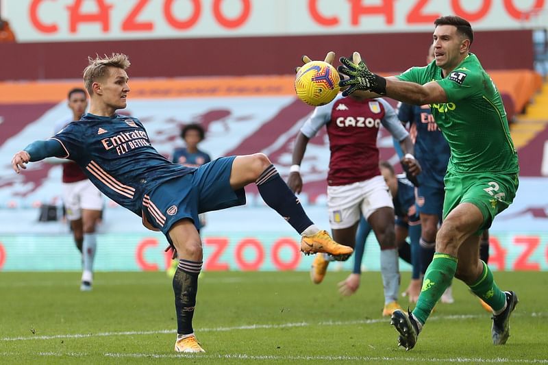 Arsenal's Norwegian midfielder Martin Odegaard (L) vies with Aston Villa's Argentinian goalkeeper Emiliano Martinez during the English Premier League football match between Aston Villa and Arsenal at Villa Park in Birmingham, central England on 6 February, 2021