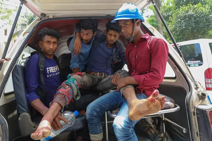 Banshkhali power plant workers with one of their injured colleagues  rushing to nearby health complex after the 17 April clash. 