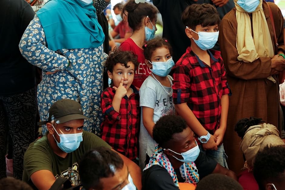 Migrant children queue to be swabbed for coronavirus disease (COVID-19) by Italian Red Cross and health authority personnel before disembarking from the German NGO migrant rescue ship Sea-Watch 3 after it arrived with 257 rescued migrants on board in Trapani on the island of Sicily, Italy, 7 August 2021. 