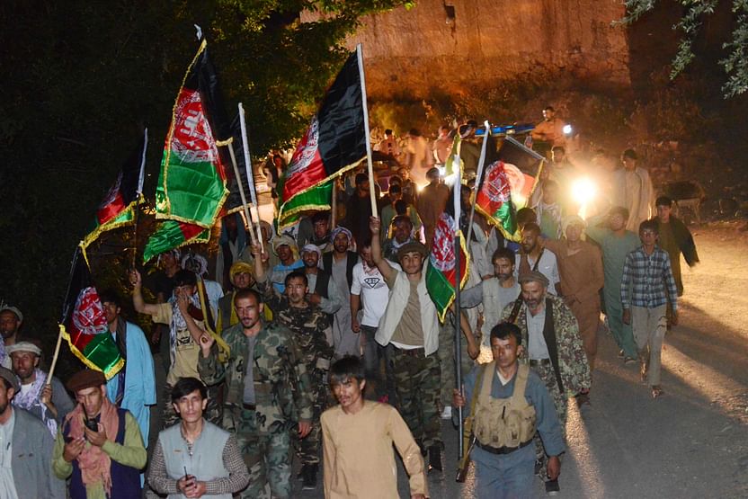 In this picture taken on 10 August 2021 people march holding the Afghan national flag and chant slogans in support of the Afghan security forces fighting against the Taliban in Panjshir province.