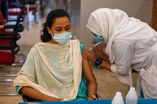 A nurse inoculates a girl with Covid-19 vaccine.
