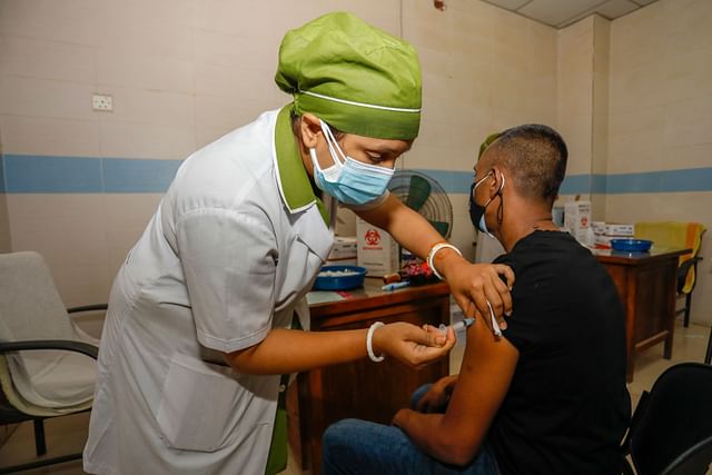 A nurse inoculates a man with Covid-19 vaccine in Dhaka. 