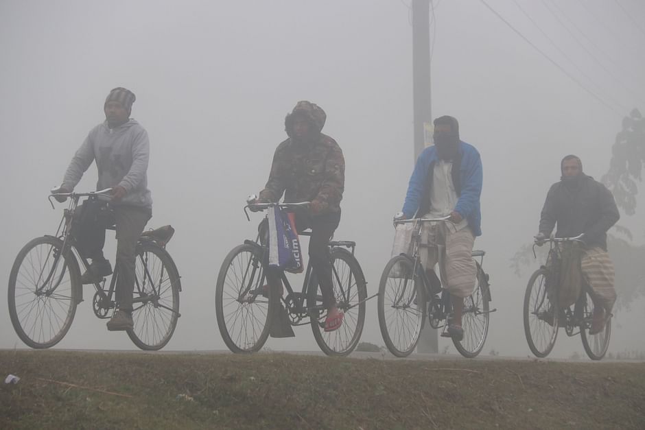 Four men ride their bicycles amid cold wave