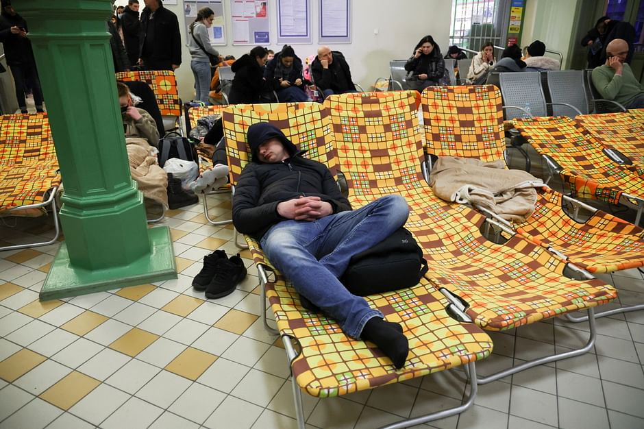 A man sleeps as people arrive at a train station converted into a refugee center, after Russia launched a massive military operation against Ukraine, in Przemysl, Poland, 25 February 2022. 