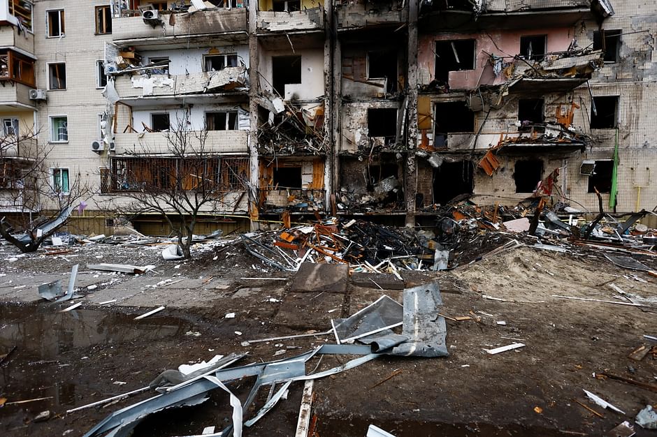 Firefighters work at a damaged residential building at Koshytsa Street, a suburb of the Ukrainian capital Kyiv, where a military shell allegedly hit, on 25 February 2022