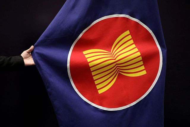 A worker adjusts an ASEAN flag at a meeting hall in Kuala Lumpur, Malaysia, 28 October 2021.