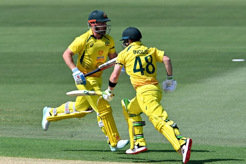 Australia's captain Aaron Finch (L) and Josh Inglis run between the wickets during the third one-day international (ODI) cricket match between Australia and New Zealand at the Cazalys Stadium in Cairns on 11 September, 2022