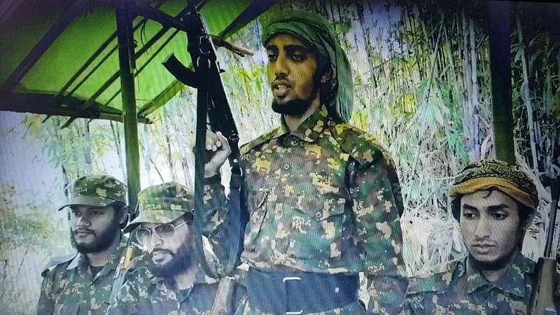 A screen grab from a video shows Jama'atul Ansar Fil Hindal Sharqiya military commander Shibbir Ahmed alias Hamid Karche wielding a firearm while Milon Talukdar (first from left), Saleh Ahmed (second from left) and Md Didar (right) are also seen.