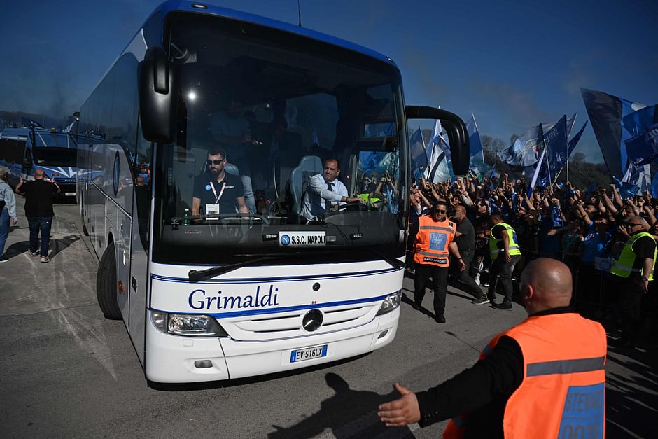 A bus transporting staff members of SSC Napoli drives past fans of SSC Napoli gathering on 5 May 2023 outside the club's training centre in Castel Volturno, north of Naples