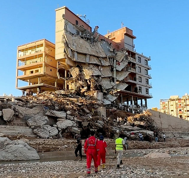 Emergency members work near a damaged building after a powerful storm and heavy rainfall hit Libya, in Derna, Libya, on 12 September, 2023 in this still image from video obtained from social media