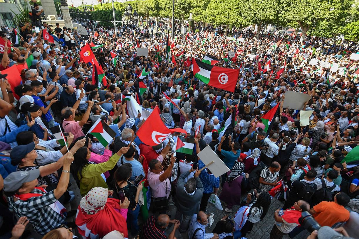 Protesters lift Palestinian and Tunisian flags and chant slogans during an anti-Israel demonstration in Tunis on12 October, 2023. In mosques, football stadiums and towns across the Arab world, pro-Palestinian sentiment has surged after a shock Hamas attack on Israel, sparking a groundswell of solidarity for the Palestinians. 