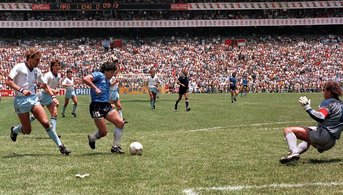 Argentinian forward Diego Armando Maradona runs past English defender Terry Butcher (L) on his way to dribbling goalkeeper Peter Shilton (R) and scoring his second goal during the World Cup quarterfinal soccer match between Argentina and England on 22 June 1986 in Mexico City. Argentina advanced to the semifinals with a 2-1 victory. Photo: AFP