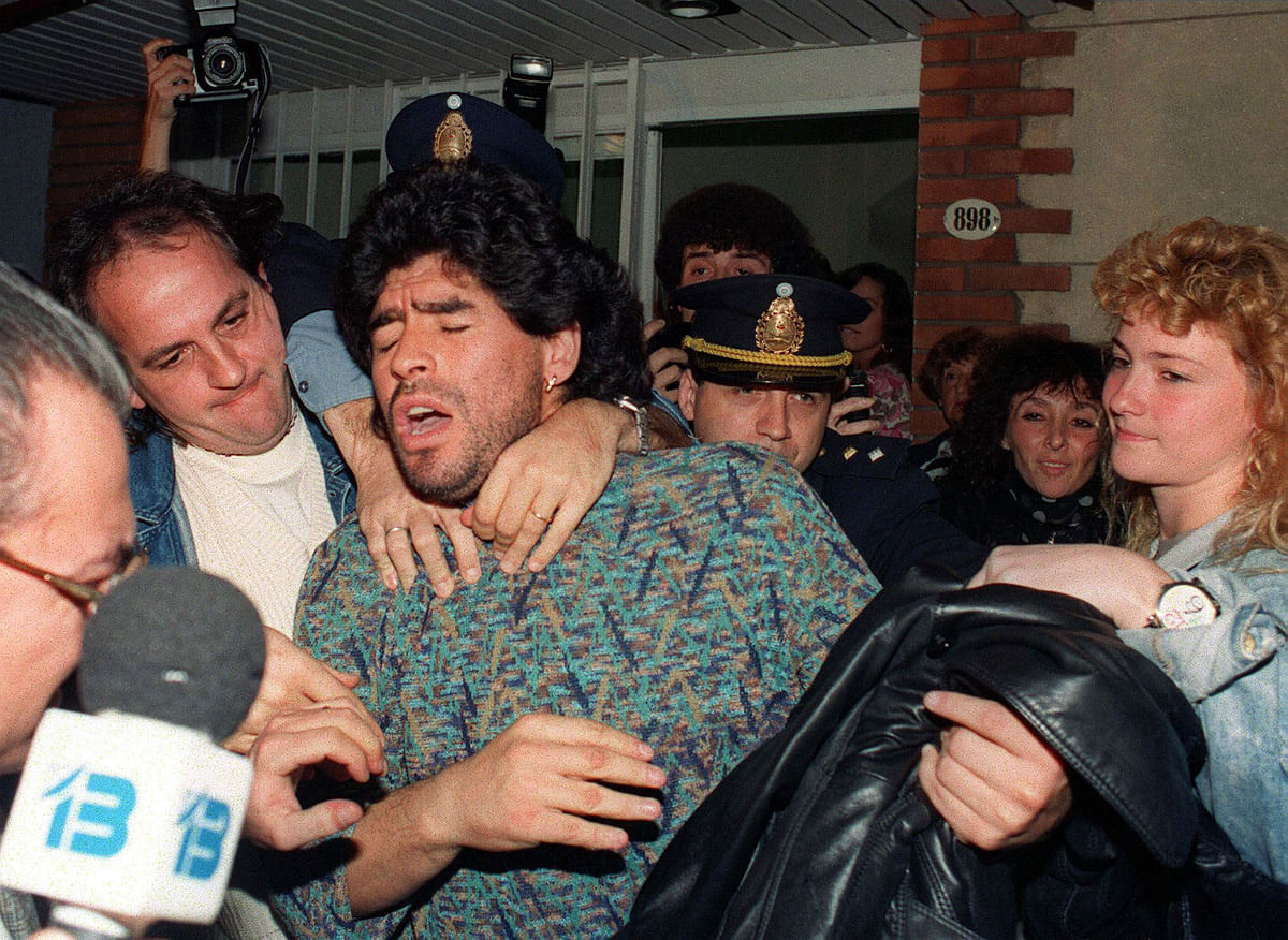 Argentinian soccer player Diego Maradona (C) is removed by police from a Buenos Aires apartment on 26 April 1991, after being arrested for possession of half-kilo of cocaine. Maradona was suspended by the Italian League 29 March 1991, after an analysis of his urine tested positive for cocaine. Photo: AFP