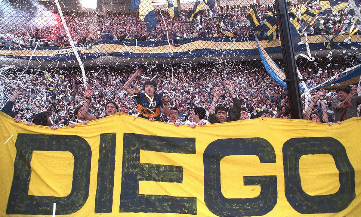 Boca Juniors fans greet their team led by Argentine controversial soccer star Diego Maradona 14 September 1997 before the game against Newell's Old Boys in Buenos Aires. This was Maradona's first game since an Argentine court recalled his suspension after testing positive for drugs twice recently. Maradona scored the first goal in a 2-1 victory over Newell's Old Boys. Photo: AFP