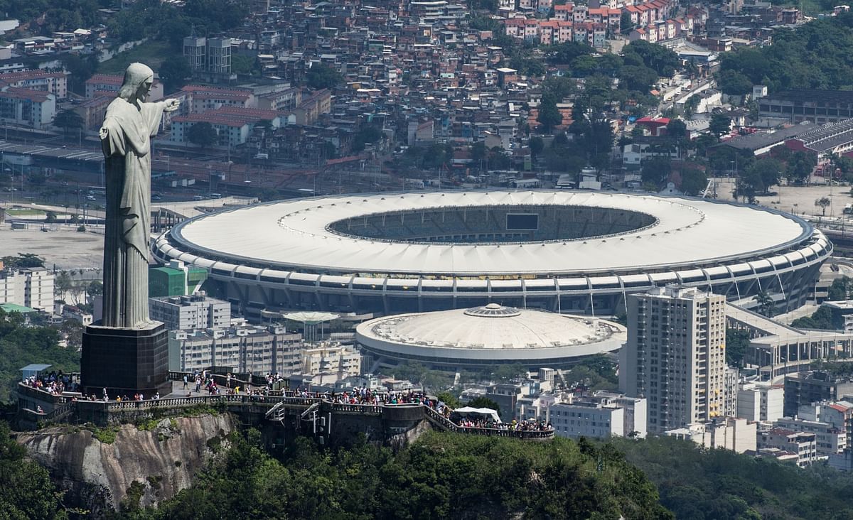 Aerial view of the Christ the Redeemer statue atop Corcovado Hill and the Mario Filho (Maracana) stadium in Rio de Janeiro, Brazil, on December 3, 2013. The Maracana stadium will host the Brazil 2014 FIFA World Cup and the 2016 Summer Olympics. Photo: AFP