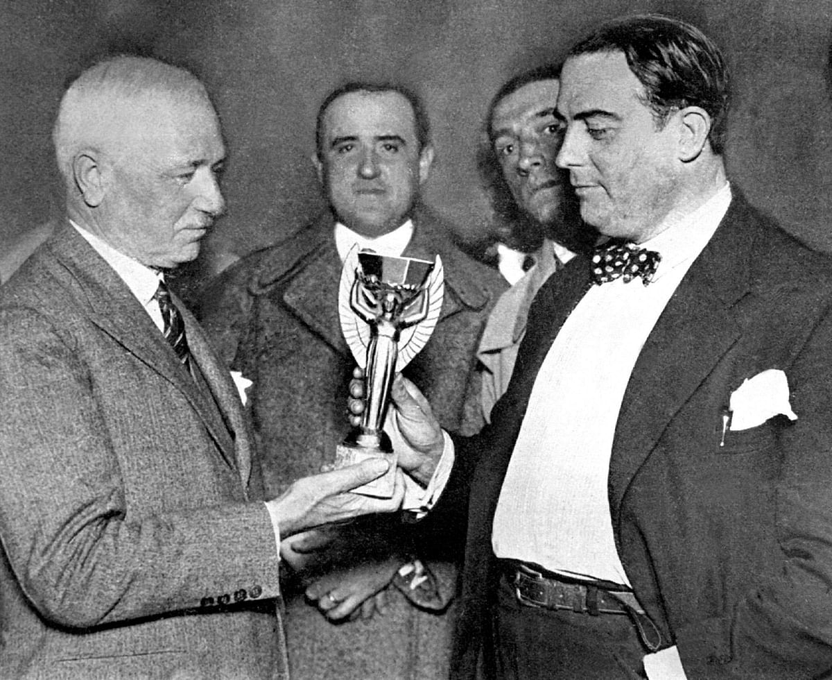 FIFA president Frenchman Jules Rimet (L) hands over the Jules Rimet trophy to Dr Raul Jude, president of the Uruguayan football association 05 July 1930 in Montevideo. The trophy will be presented to the captain of the winning team of the first World Cup, staged in Uruguay from 13 July to 30 July. Photo: AFP