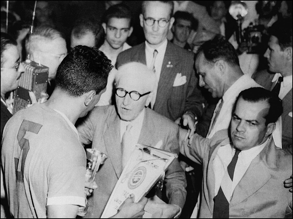 Le président de la FIFA, Jules Rimet (C), remet la Coupe de Monde de Football à Obdulio Varela, le capitaine uruguayen (de dos) dont l'équipe a battu le Brésil deux buts à un, le 16 juillet 1950 à Rio de Janeiro. Photo: AFP