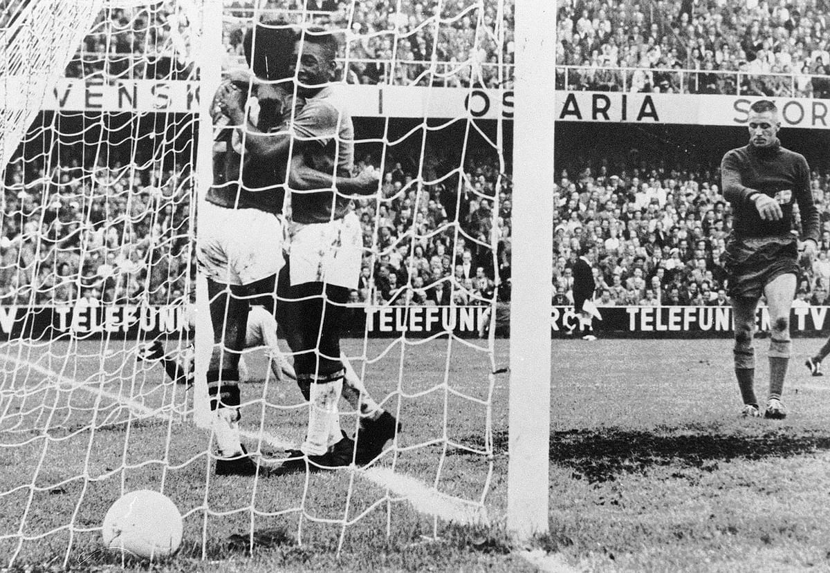 Brazilian forward Pele (C) congratulates his teammate Vava (20) after he scored a goal as Swedish goalkeeper Karl Svensson reacts on 29 June 1958 in Stockholm during the World Cup final against Sweden. Vava and Pele scored two goals each as Brazil won its first title beating World Cup host Sweden 5-2. Photo: AFP
