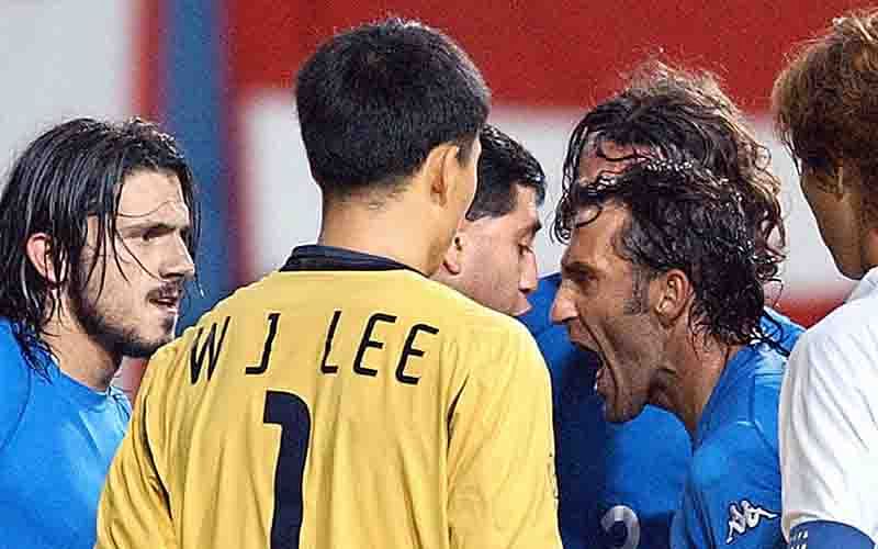 Surrounded by Italian and South Korean players, Italian midfielder Angelo Di Livio (C) shouts at referee Byron Moreno (3rd R-hidden) as the official gets set to issue a red card to Italy's Francesco Totti (not pictured) during extra time of their second round match at the 2002 FIFA World Cup Korea/Japan in Daejeon on 18 June 2002. Photo: AFP