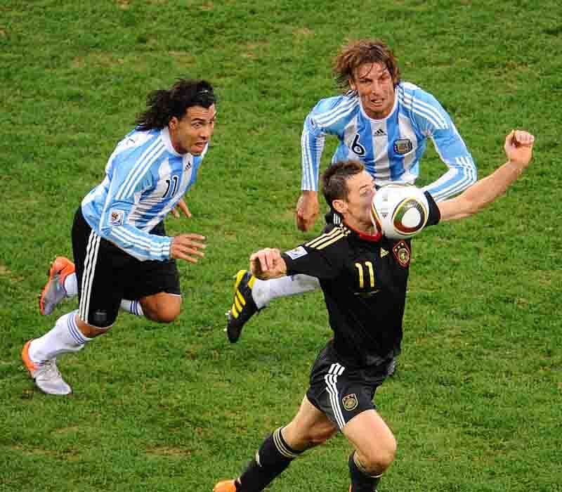 Germany's striker Miroslav Klose takes tball as he is chased by Argentina's striker Carlos Tevez (L) and defender Gabriel Heinze during the 2010 World Cup quarter-final football match Argentina vs. Germany on July 3, 2010 at Green Point stadium in Cape Town. Photo: AFP