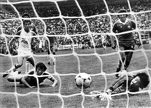 Algerian forward Salah Assad (L) scores his second goal as Chilean defender Rodolfo Dubo (L, on ground) and goalkeeper Mario Osben watch the ball go into the net on 24 June 1982 in Oviedo during the World Cup first round soccer match between Algeria and Chile. Algeria beat Chile 3-2. Photo: AFP