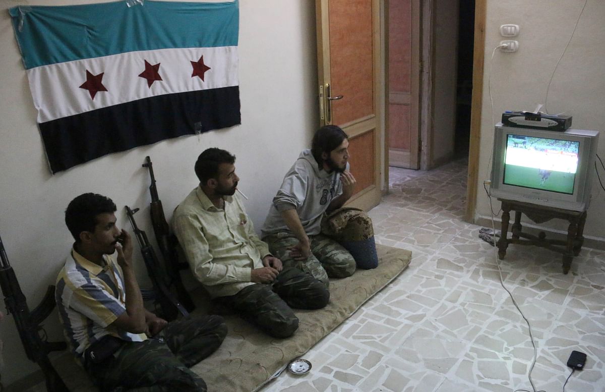 . Rebel fighters watch on television the opening World Cup 2014 football match between Brazil and Croatia on June 12, 2014 in the northern Syrian city of Aleppo. Photo: AFP