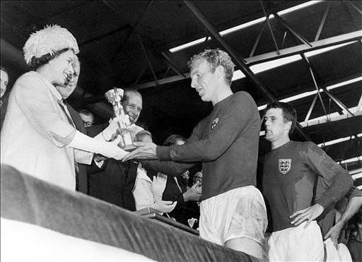 Queen Elizabeth of England presents the Jules Rimet Cup to Bobby Moore, captain of England's national soccer team, as her husband Prince Philip (C) and forward Geoff Hurst (R) look on after England beat West Germany 4-2 in extra time in the World Cup final 30 July 1966 at Wembley stadium in London. AFP