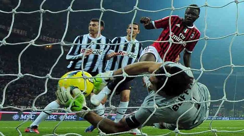 Juventus goalkeeper Gianluigi Buffon grabs the ball in front of AC Milan midfielder Sulley Ali Muntari of Ghana on February 25, 2012 during a Serie A match at the San Siro stadium in Milan. AFP