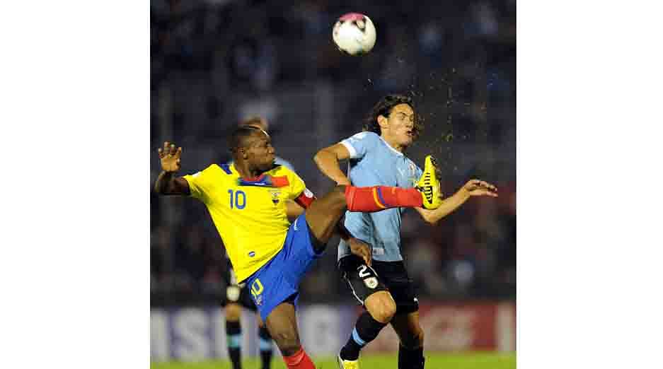 Uruguayan forward Edinson Cavani (R) vies for the ball with Ecuadorean defender Walter Ayovi during their Brazil 2014 FIFA World Cup South American qualifier match held at the Centenario Stadium in Montevideo on September 11, 2012. AFP