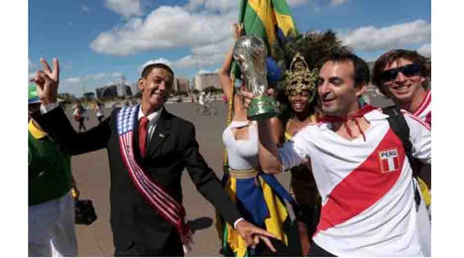 A soccer fan dressed as U.S. President Barack Obama and a fan dressed in Peru jersey carrying a mock World Cup trophy arrive at the national stadium to watch Switzerland play against Ecuador in a 2014 World Cup match, in Brasilia June 15, 2014. Reuters