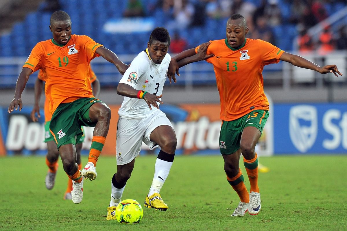 Ghanaian national football team's Asamoah Gyan (C) vies with Zambian defender Stoppila Sunzu (R) and midfielder Nathan Sinkala during the Africa Cup of Nations (CAN) semi-final football match between Ghana and Zambia in Bata on Feburary 8, 2012. Zambia won 1-0 and qualified for the final. AFP