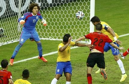 Brazil's Thiago Silva (top R) heads the ball but fails to get it past Mexico's Guillermo Ochoa (L) during their 2014 World Cup Group A soccer match at the Castelao arena in Fortaleza on June 17, 2014. Reuters