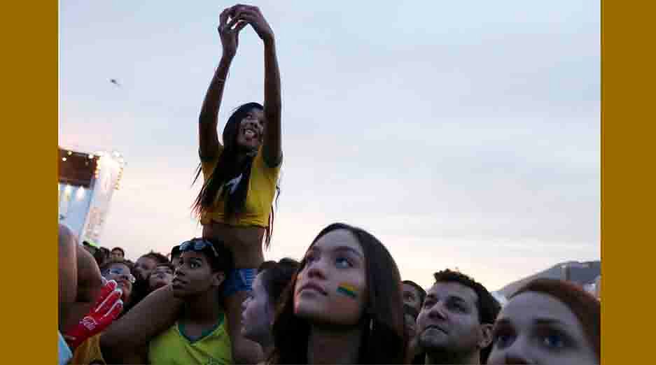 A Brazilian soccer fan takes a selfie as she watches the match being played in Brasilia between Brazil and Cameroon, which was broadcast on a large screen at Copacabana beach in Rio de Janeiro, June 23, 2014. Reuters