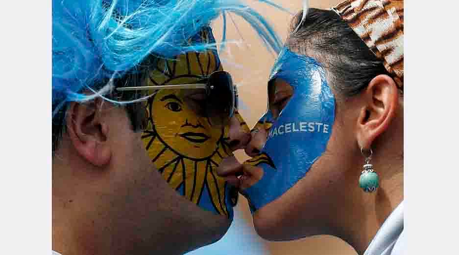 Uruguay supporters kiss before the start of their 2014 World Cup Group D soccer match against Italy at the Dunas arena in Natal on June 24, 2014. Reuters