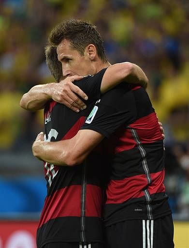 Germany's forward Miroslav Klose (R) celebrates with teammates after scoring during the semi-final football match between Brazil and Germany at The Mineirao Stadium in Belo Horizonte on July 8, 2014, during the 2014 FIFA World Cup . AFP