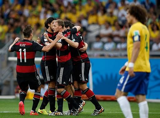 Germany's forward Thomas Mueller (C) celebrates with teammates after scoring during the semi-final football match between Brazil and Germany at The Mineirao Stadium in Belo Horizonte during the 2014 FIFA World Cup on July 8, 2014. AFP