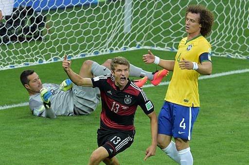 Germany's forward Thomas Mueller (C) celebrates after he scored their first goal during the semi-final football match between Brazil and Germany at The Mineirao Stadium in Belo Horizonte during the 2014 FIFA World Cup on July 8, 2014. AFP