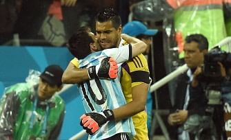 Argentina's goalkeeper Sergio Romero (R) celebrates with Argentina's forward and captain Lionel Messi afetr his successful kick during a penalty shoot out following extra-time in the semi-final football match between Netherlands and Argentina of the FIFA World Cup at The Corinthians Arena in Sao Paulo on July 9, 2014. AFP