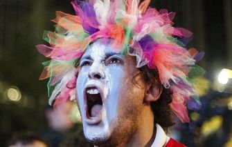 An Argentine fan celebrates while watching the FIFA World Cup Brazil 2014 semi-final football match against Netherlands in Sao Paulo, Brazil on July 9, 2014. Argentina beat the Netherlands 4-2 in penalty kicks and will face Germany in the FIFA World Cup final on July 13. AFP