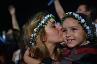 Argentine fans kisses her child as Argentina beat Netherlands in a penalty shoot out after extra time at a live broadcast of the semi-final match between Argentina and Netherlands of the FIFA World Cup 2014 at Copacabana beach in Rio de Janeiro on July 9, 2014. AFP